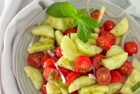 Ready to serve Cucumber, tomato Salad with Mint in grey serving bowl.